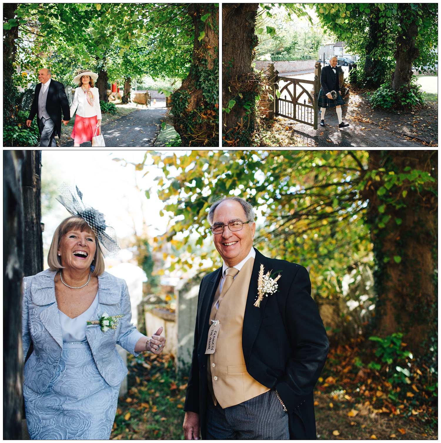 Father of the groom is smiling at the camera. He is wearing a morning suit, a button hole and has a label hanging from a button saying "father of the groom". His wife, dressed in blue, laughs. They are outside St Thomas' Church in Bradwell-on-Sea and it's autumn.