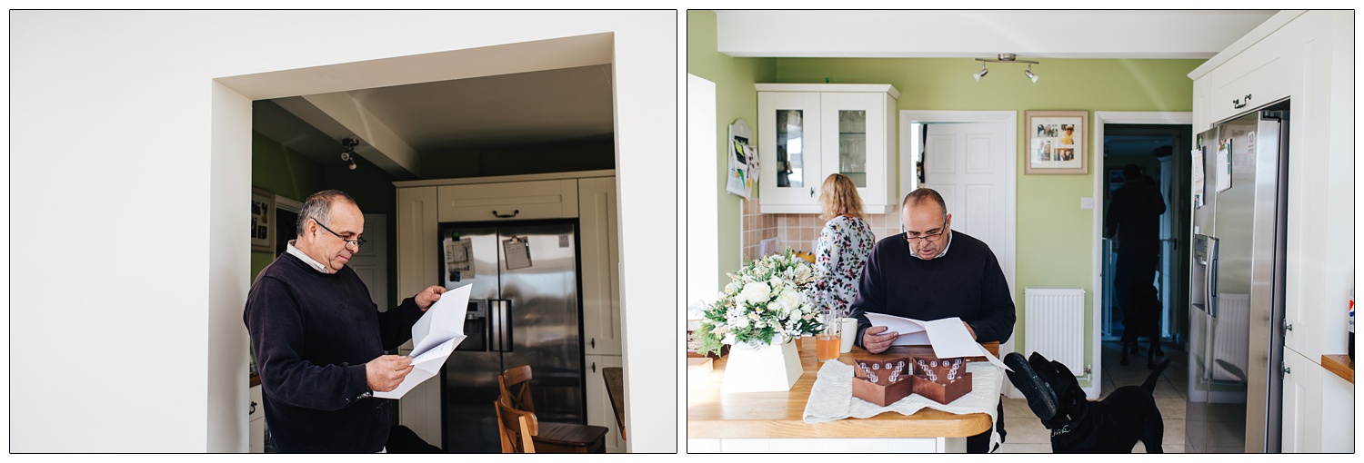 Father of the bride in a kitchen checking his speech, a black dog offers him a shoe.