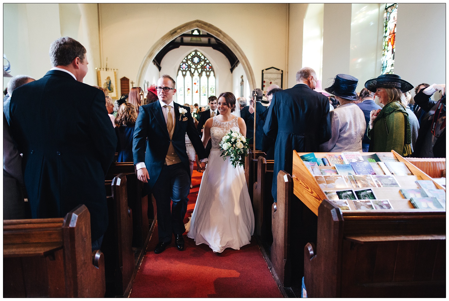 Just married and walking down the aisle of an Essex church