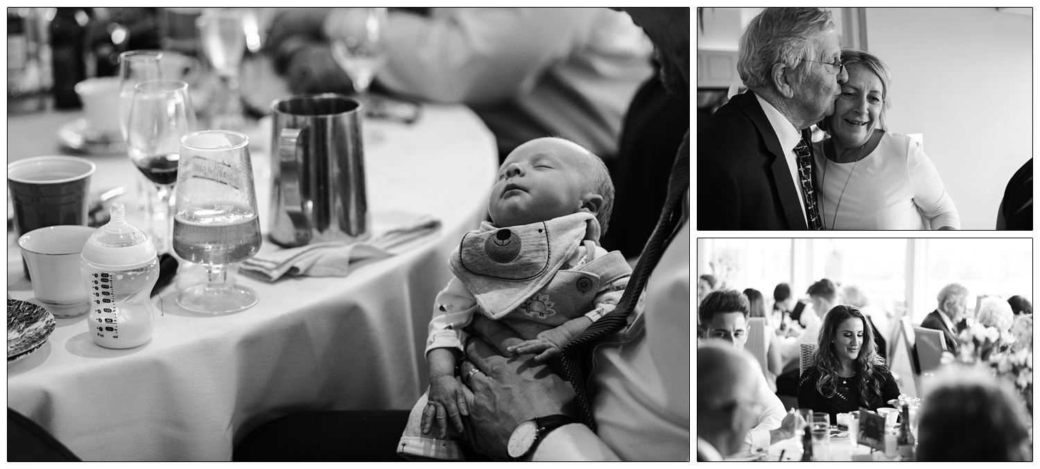 A newborn baby has fallen asleep after being fed. His bottle is next to a glass of beer, they are sat at a table for a wedding reception.
