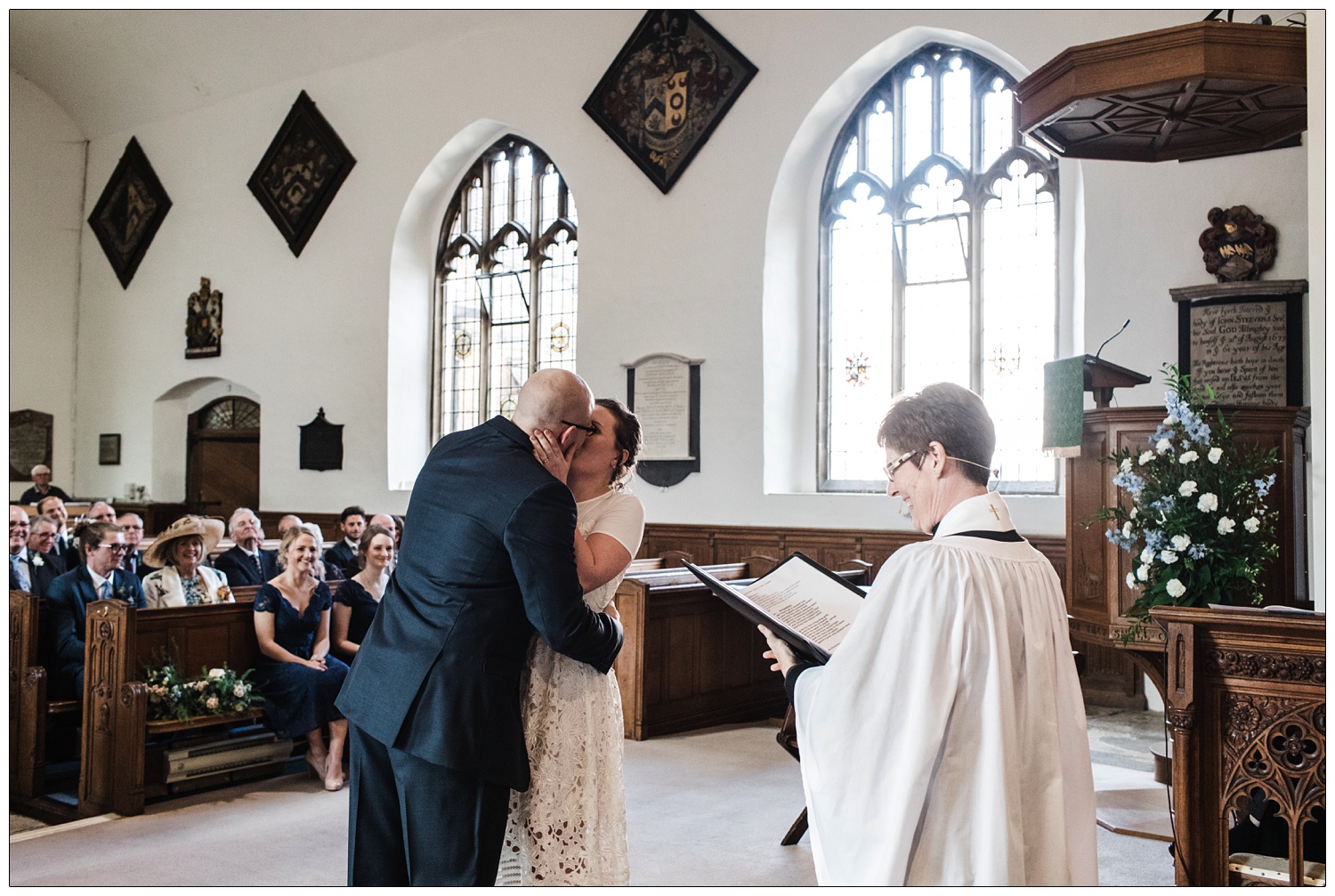 The newly married couple kiss during wedding ceremony at All Saints with St Peter Church of England Maldon