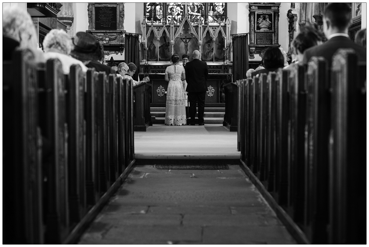 Bride and groom stood at the altar in St Peter's in Maldon.