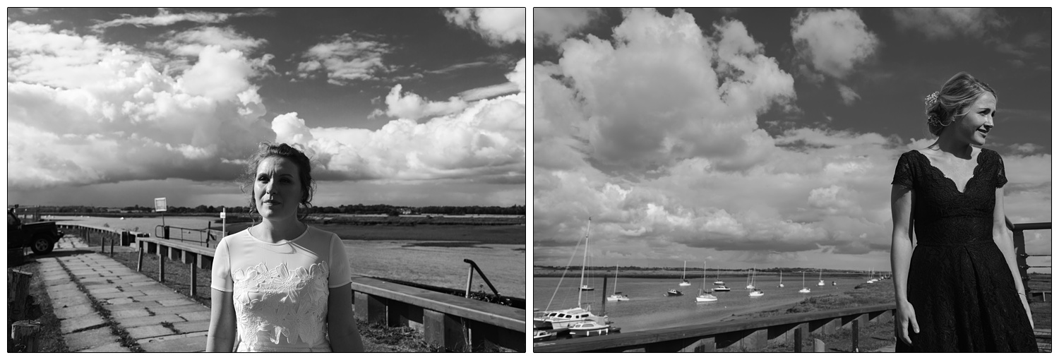 Bride and a bridesmaid outside by the River Crouch with clouds in the sky. the pictures are in black and white.