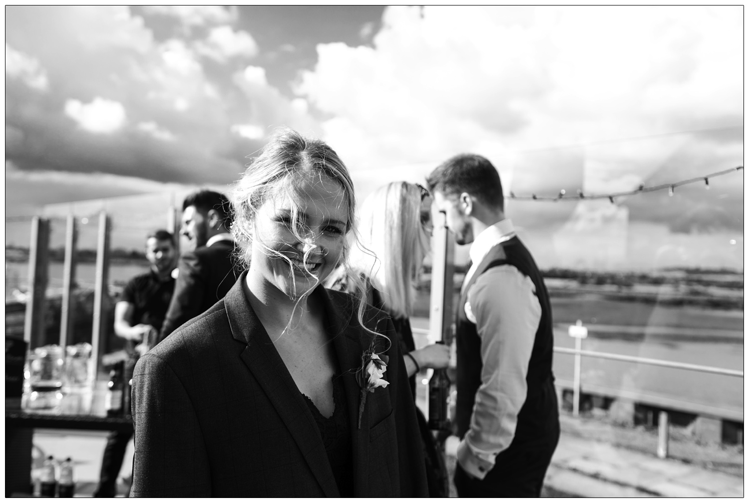 Bridesmaid wearing a man's jacket over her dress to keep warm.