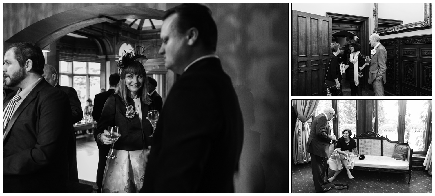 Bride's mum carrying a glass of wine in a candid photograph in the rock room at Manor by the Lake.