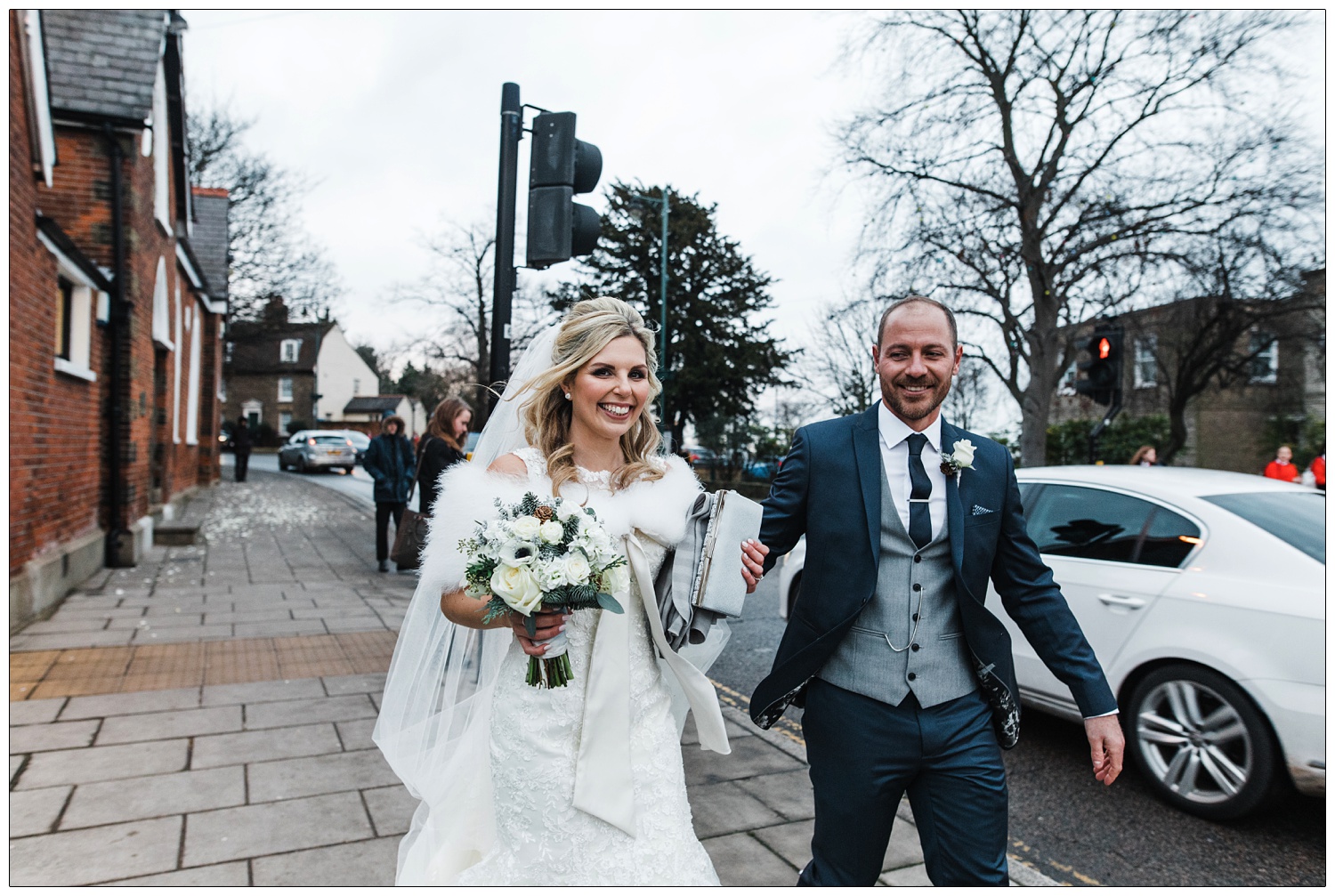 Bride and groom walk along the street in Rayleigh.