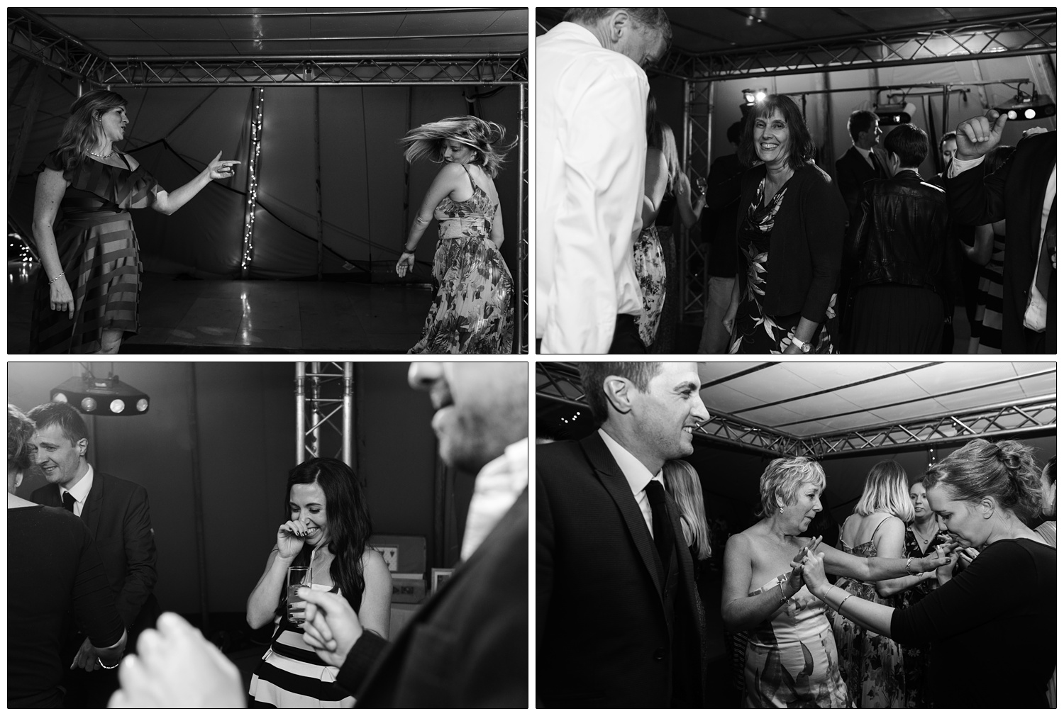 Reportage style black and white photographs at a wedding reception near Colchester. The Browning Bros. Chalkney Water Meadows venue. Two women are dancing, one is shaking her head and the other is pointing. The bride is laughing in a stripy dress.