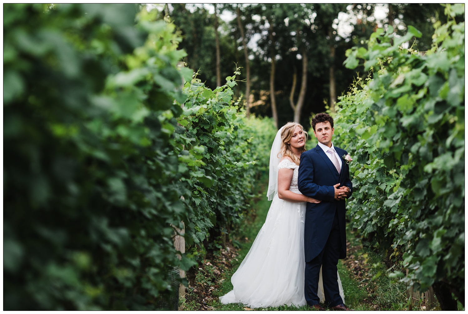 Bride and groom posing in the Bardfield vineyard at the Great Lodge venue.