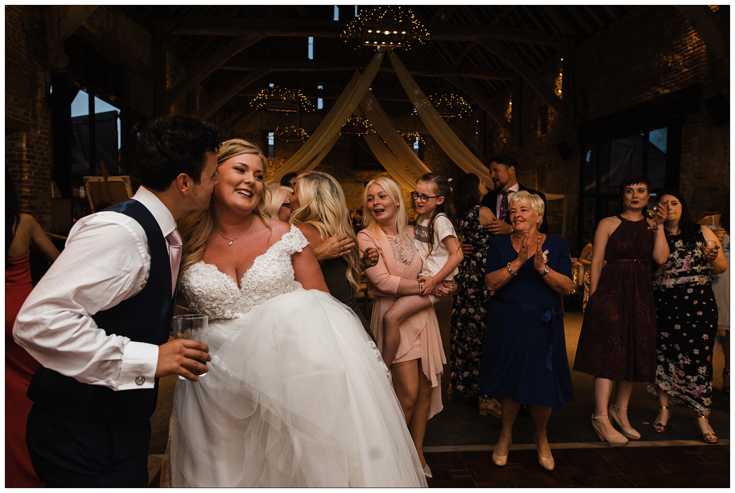 Man kisses new wife at evening reception.