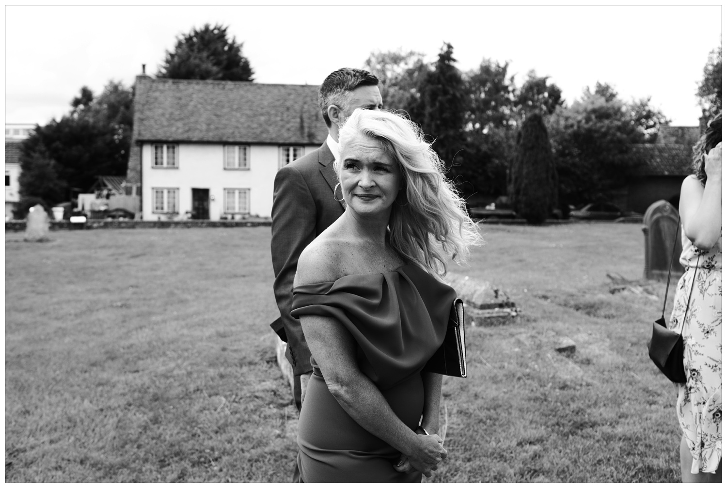 Woman in an off the shoulder dress and hair blowing in the wind.