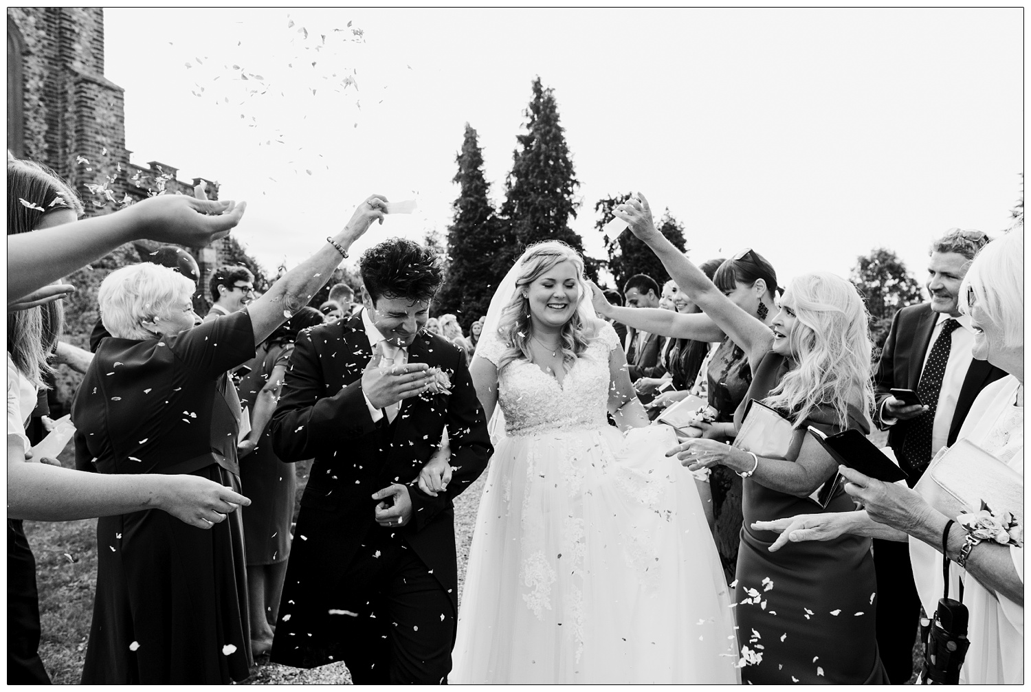 Just married couple covered in confetti their friends and family are throwing.