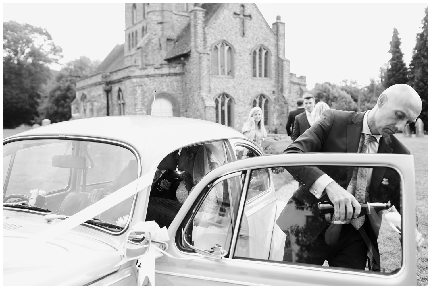 Driver of the wedding car pouring prosecco.
