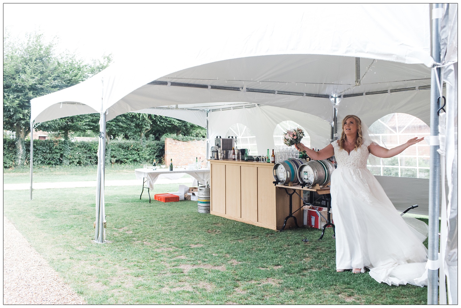 Bride using her arms to respond to the rain on her wedding day.