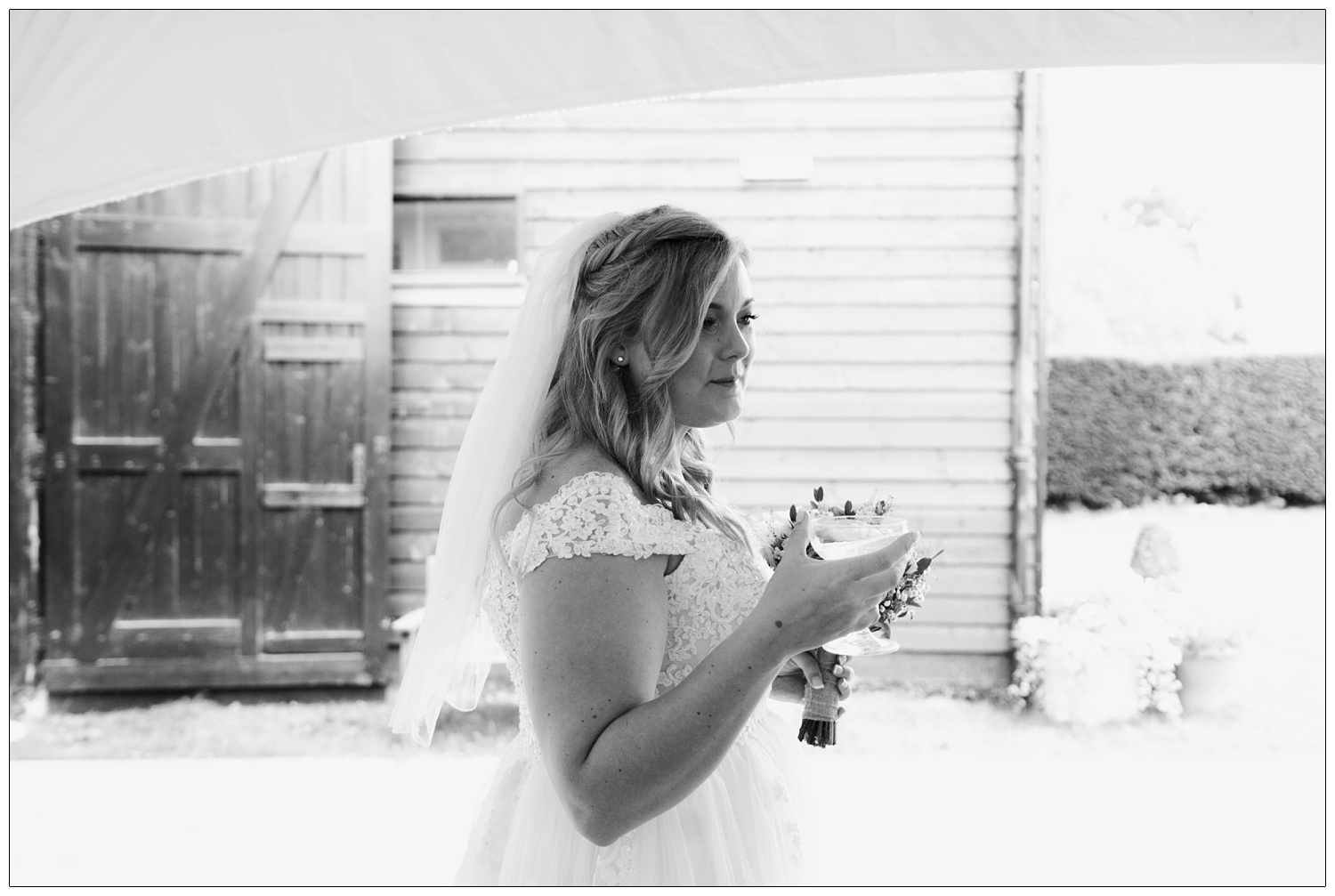 Bride outside holding a champagne coupe.