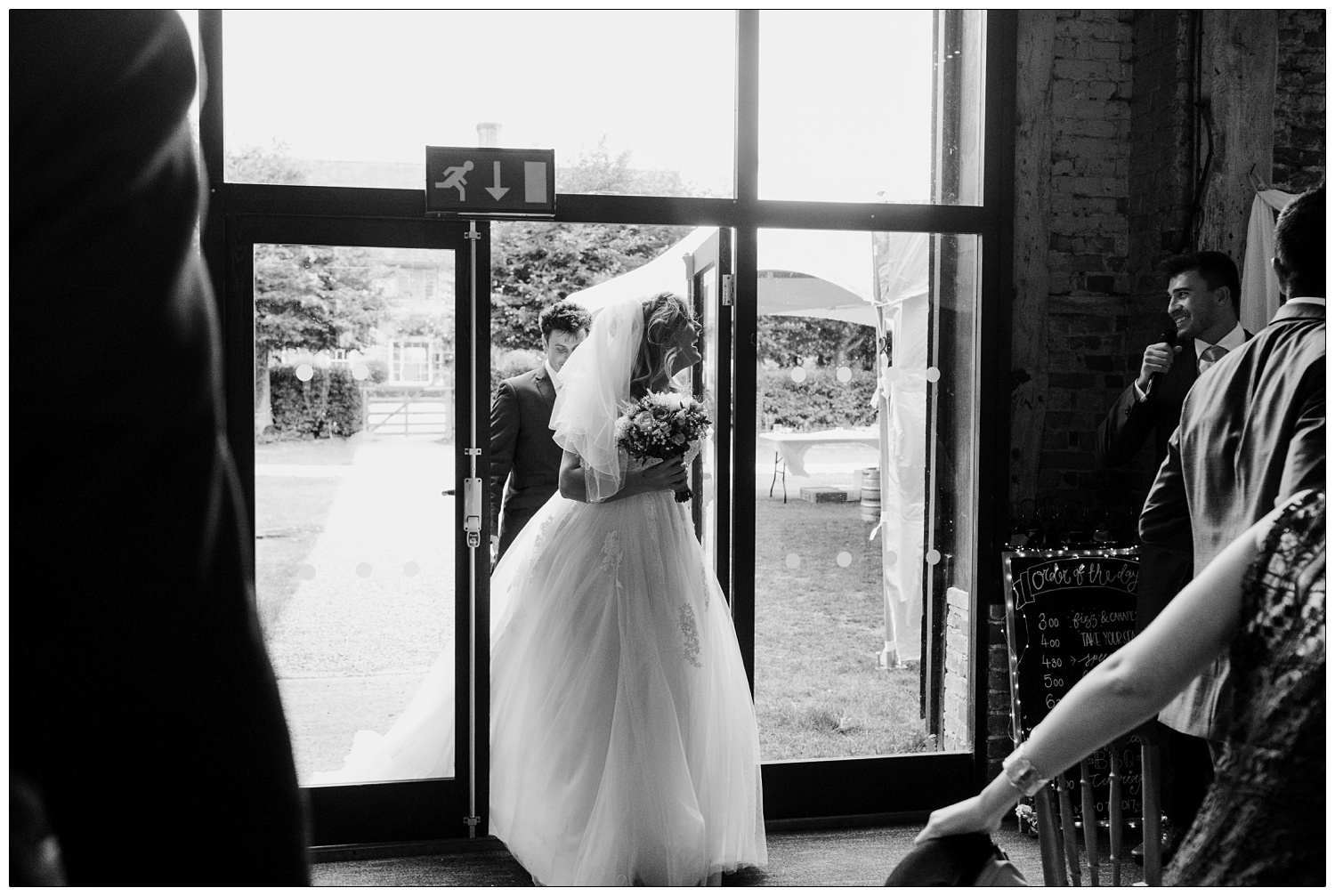 Bride and groom entering the barn