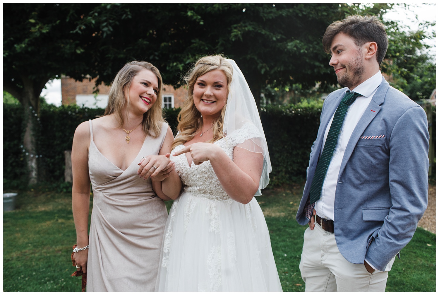 Bride pointing to her friend's engagement ring.