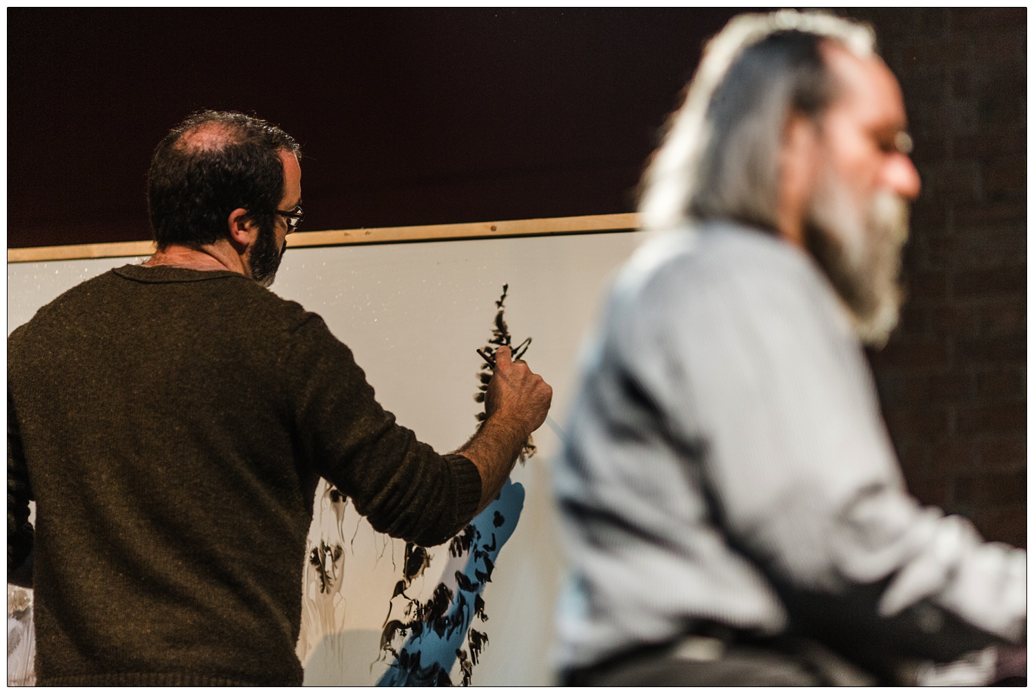 Photograph of out of focus Lubomyr Melnyk playing the piano and Gregory Euclide paints