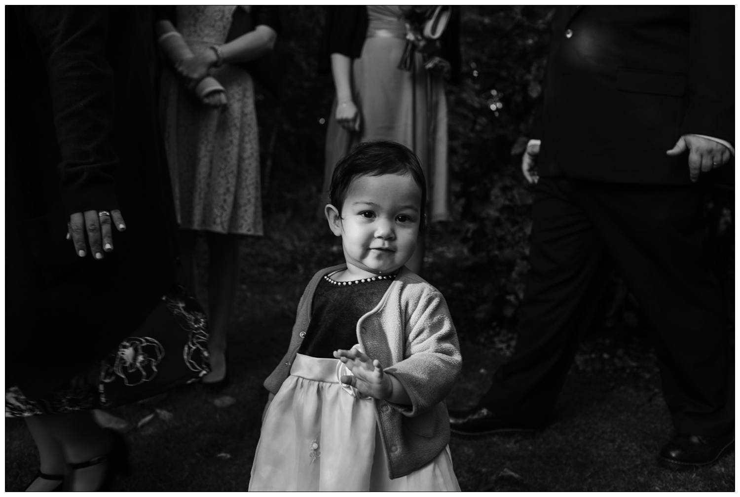 A little girl looks at the camera at a wedding.