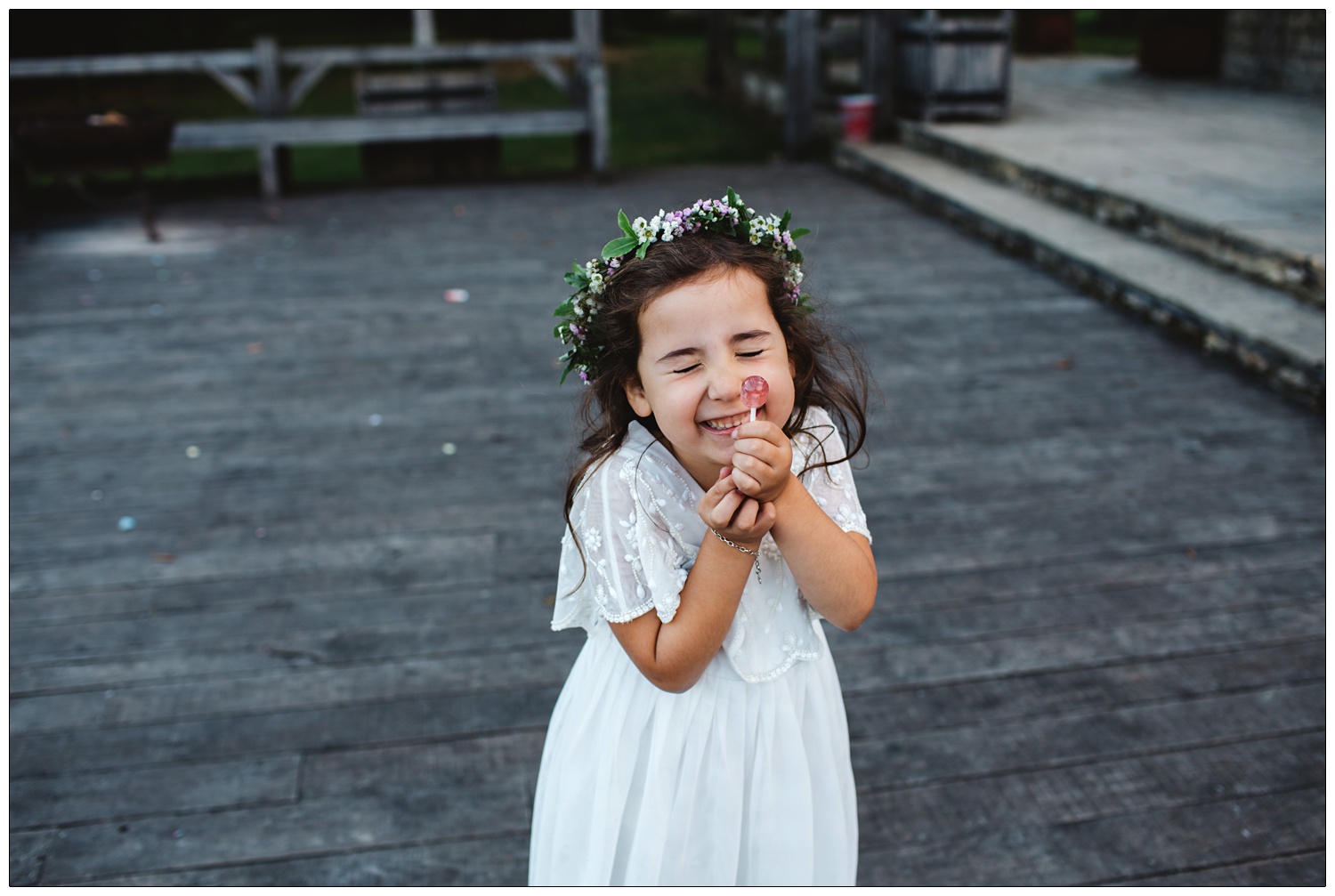 A flowergirl is happy to have a lollipop.