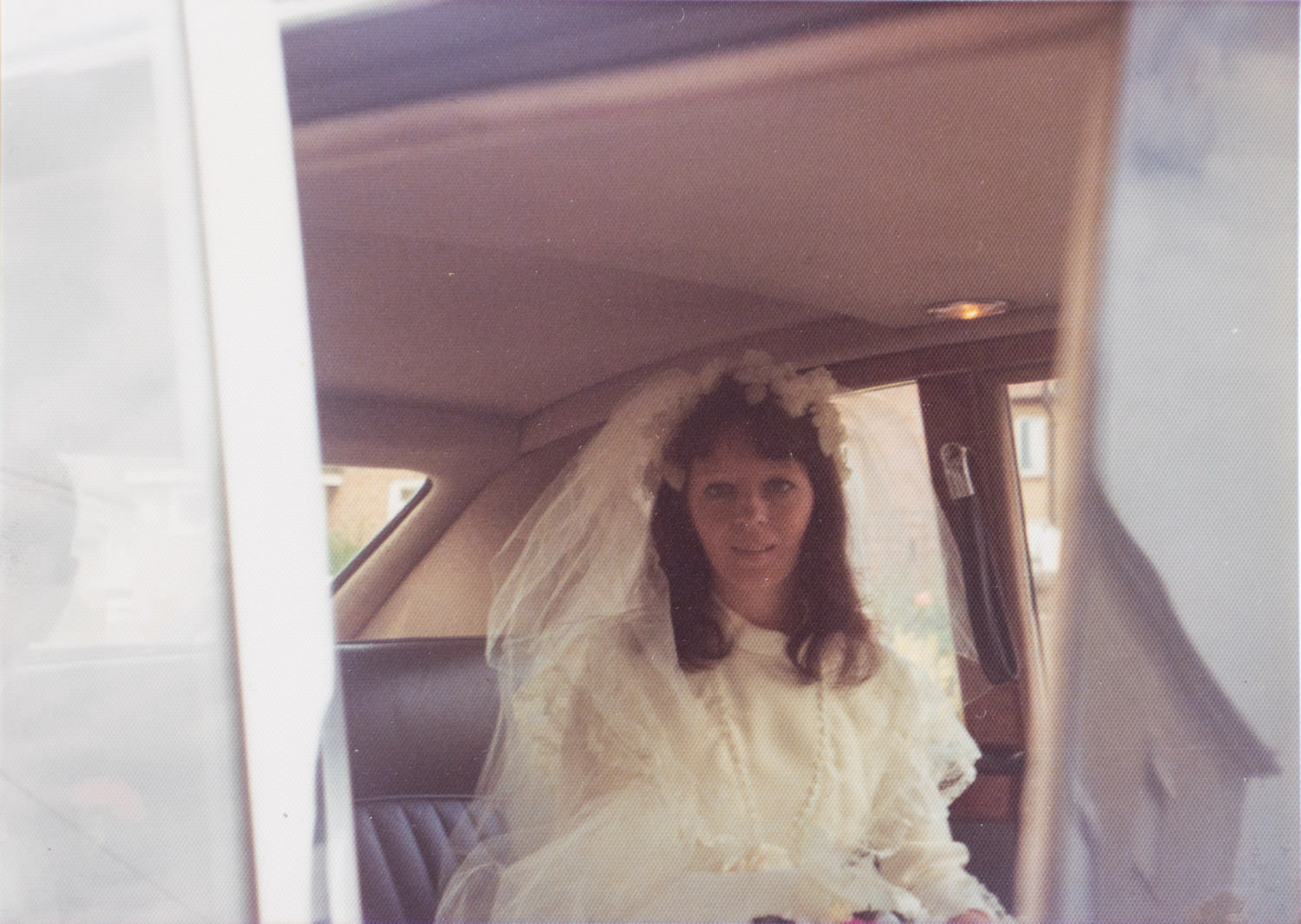 A bride in a car on her wedding in July 1075 in Rainham. She is wearing a veil.