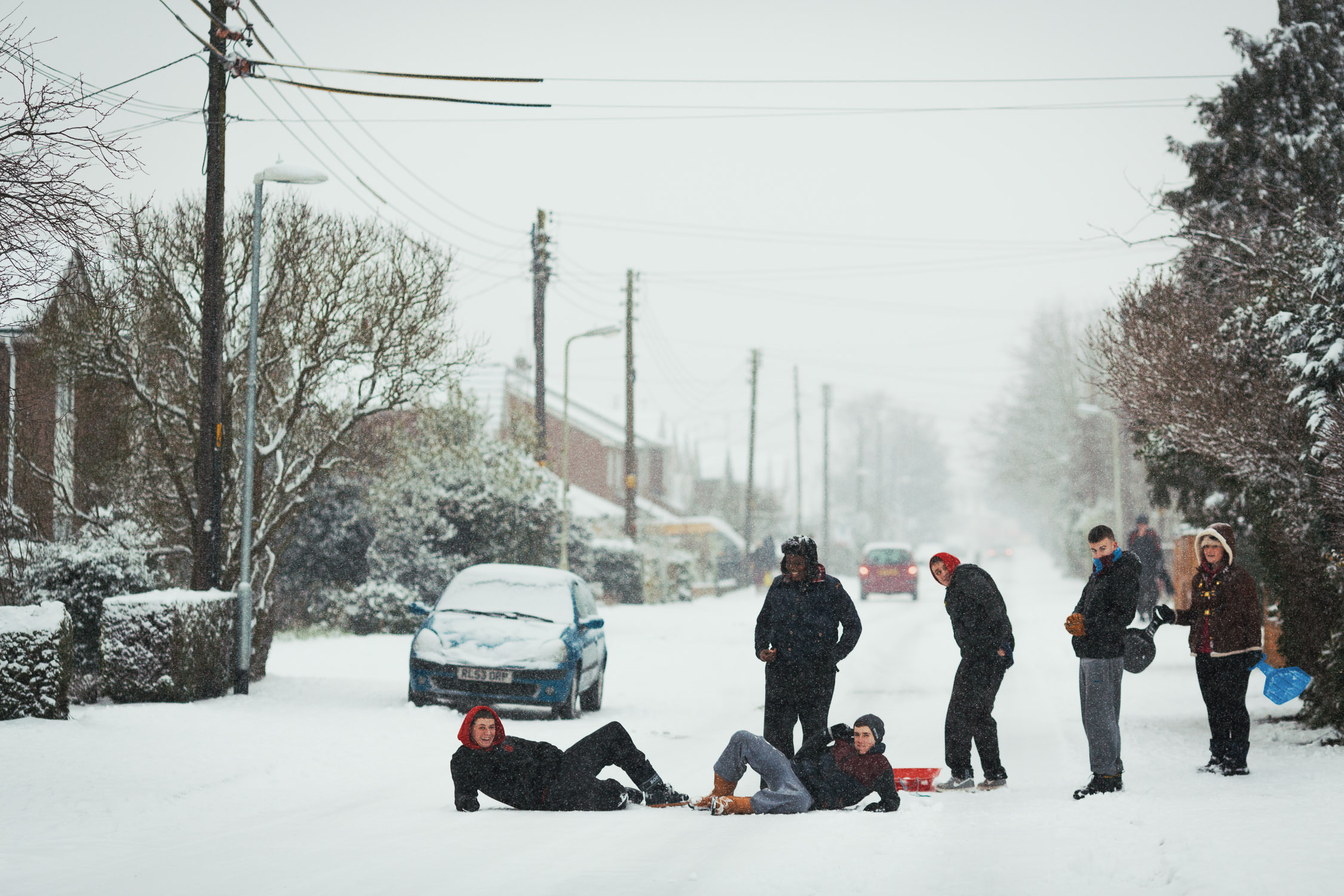 Young people in the middle of the road in the snow. King Edward's Road in South Woodham Ferrers near Chelmsford.