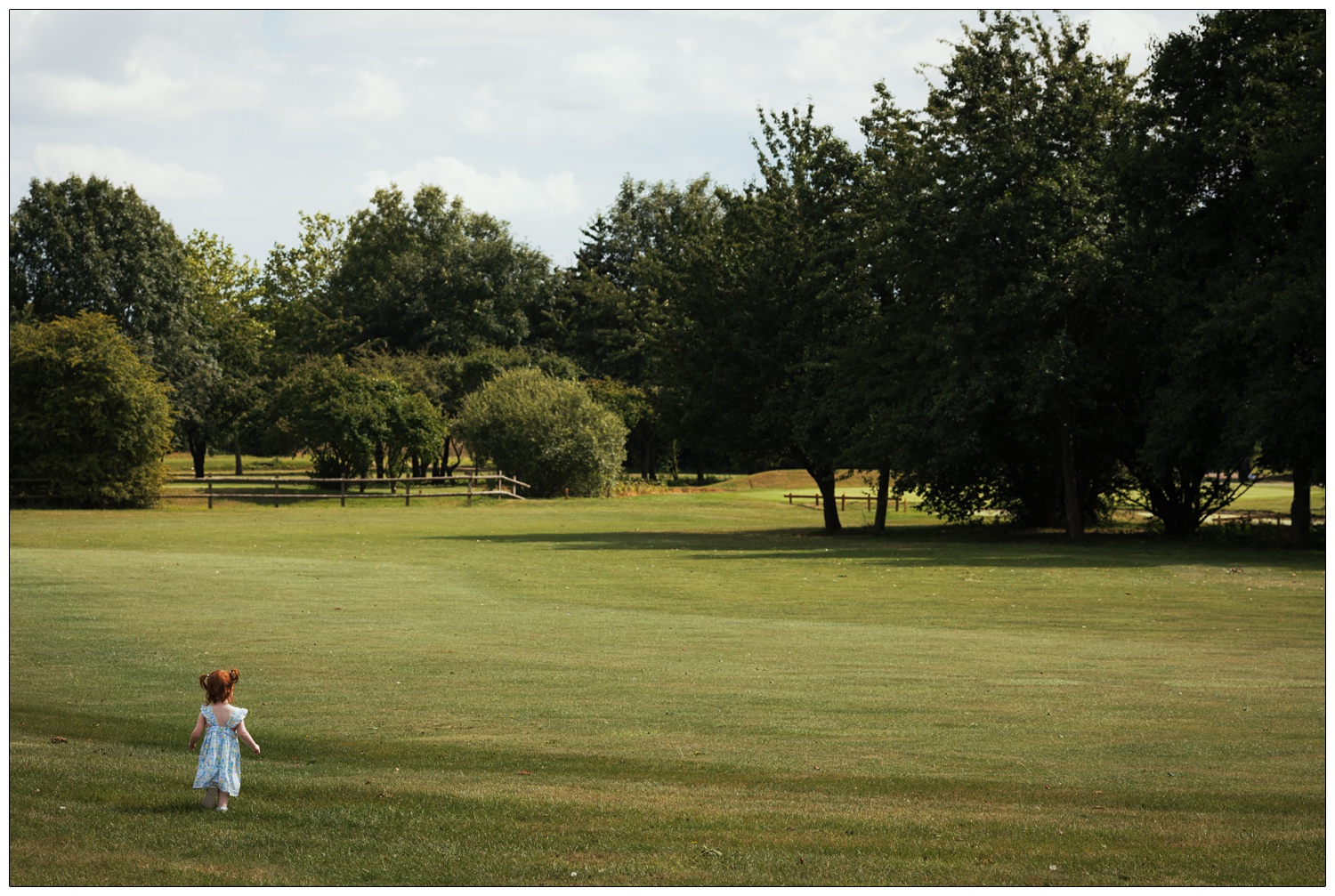 A toddler runs off across the golf course at a wedding reception at Fynn Valley Terrace.