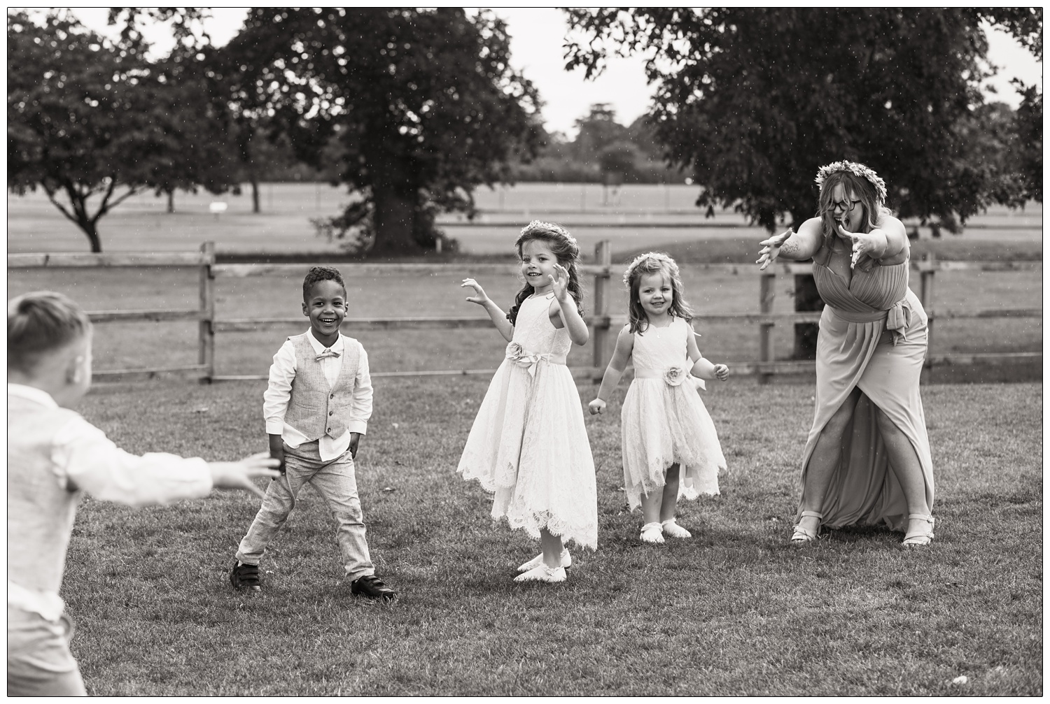 A bridesmaid playing with the children in the rain at a wedding near Ipswich.