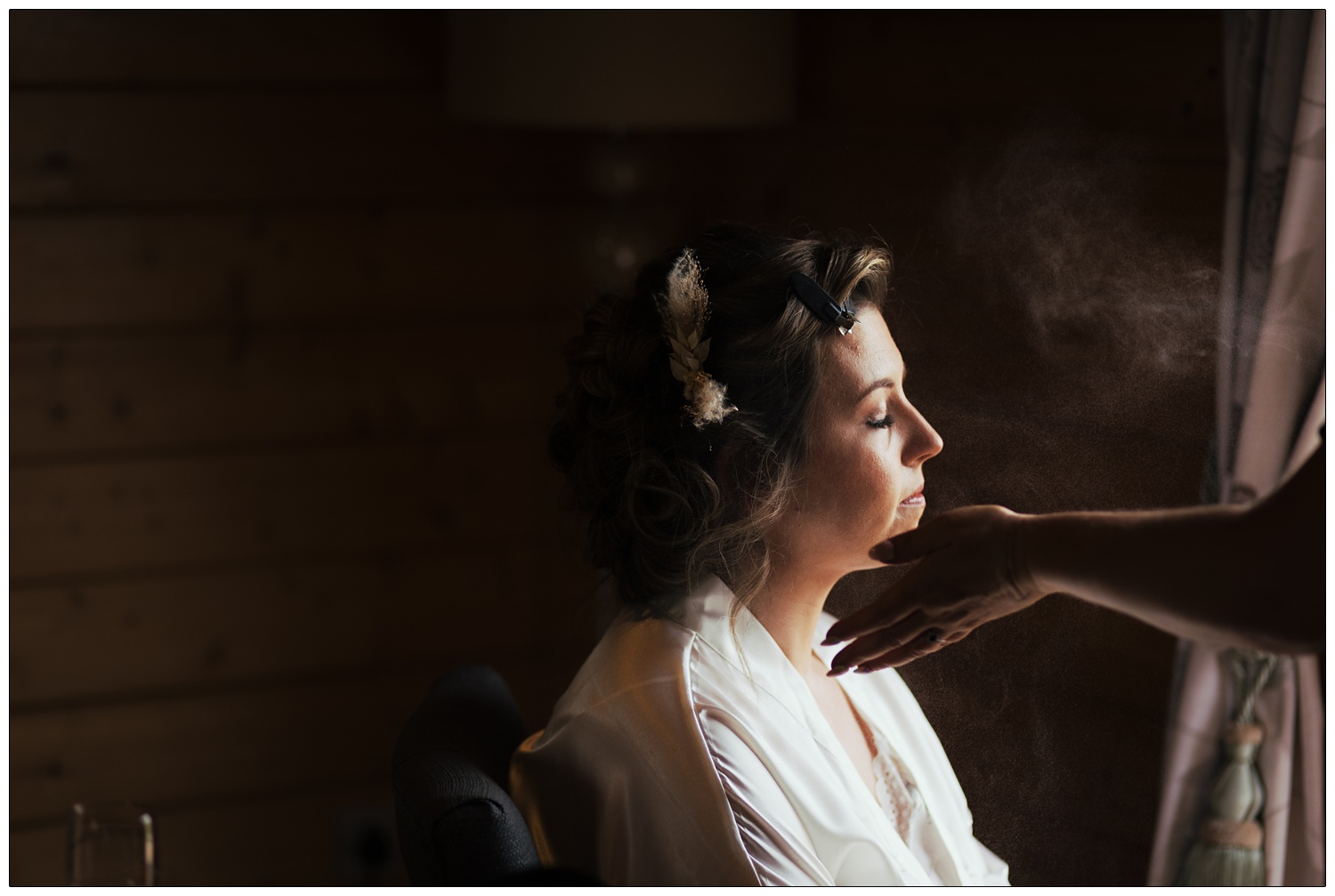 A mist is applied to a bride's face to set her make up.