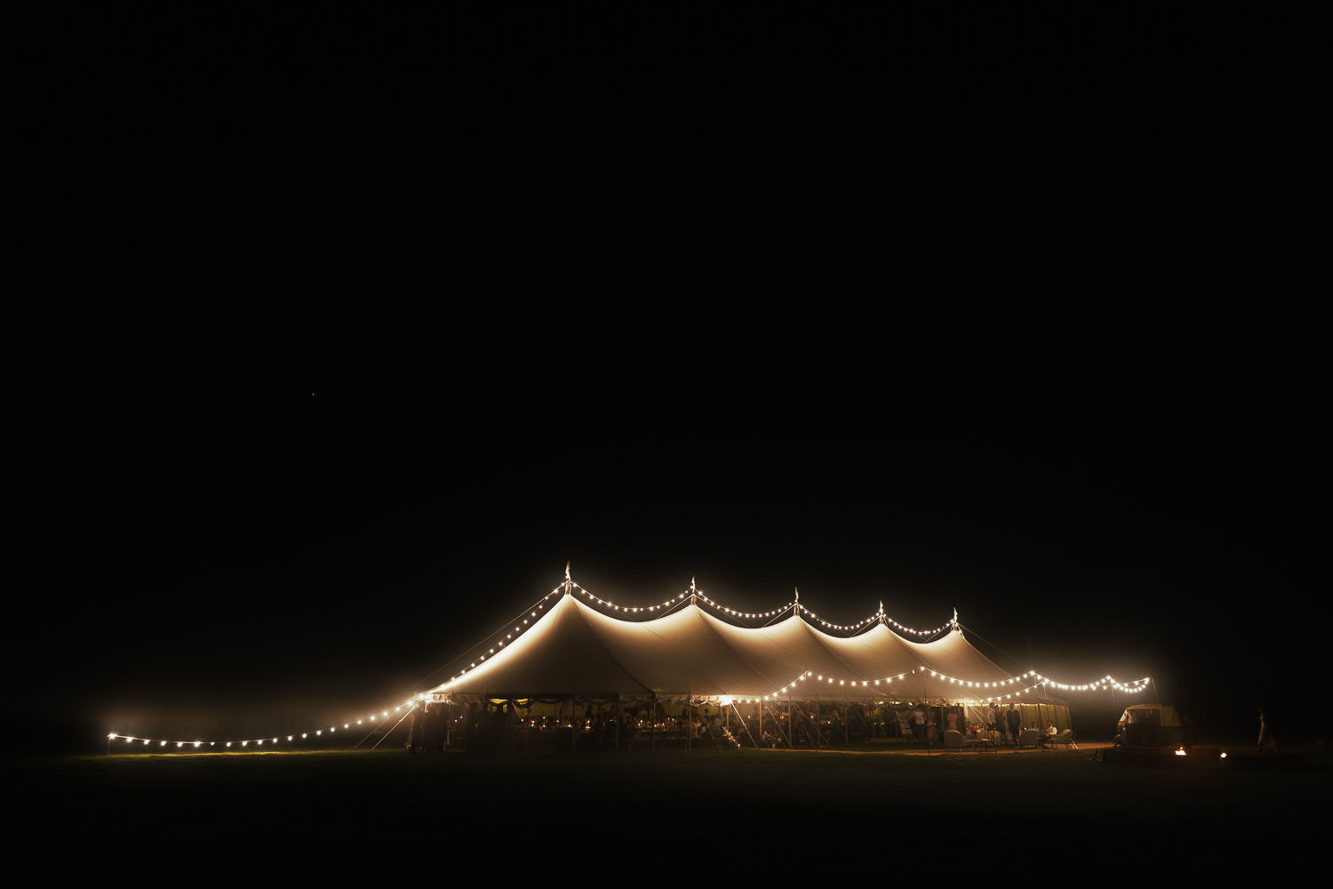 A Sail & Peg marquee lit up at night at a wedding on a Crouch vineyard near South Woodham Ferrers in Essex. Where documentary wedding photographer Tracy Morter is based.