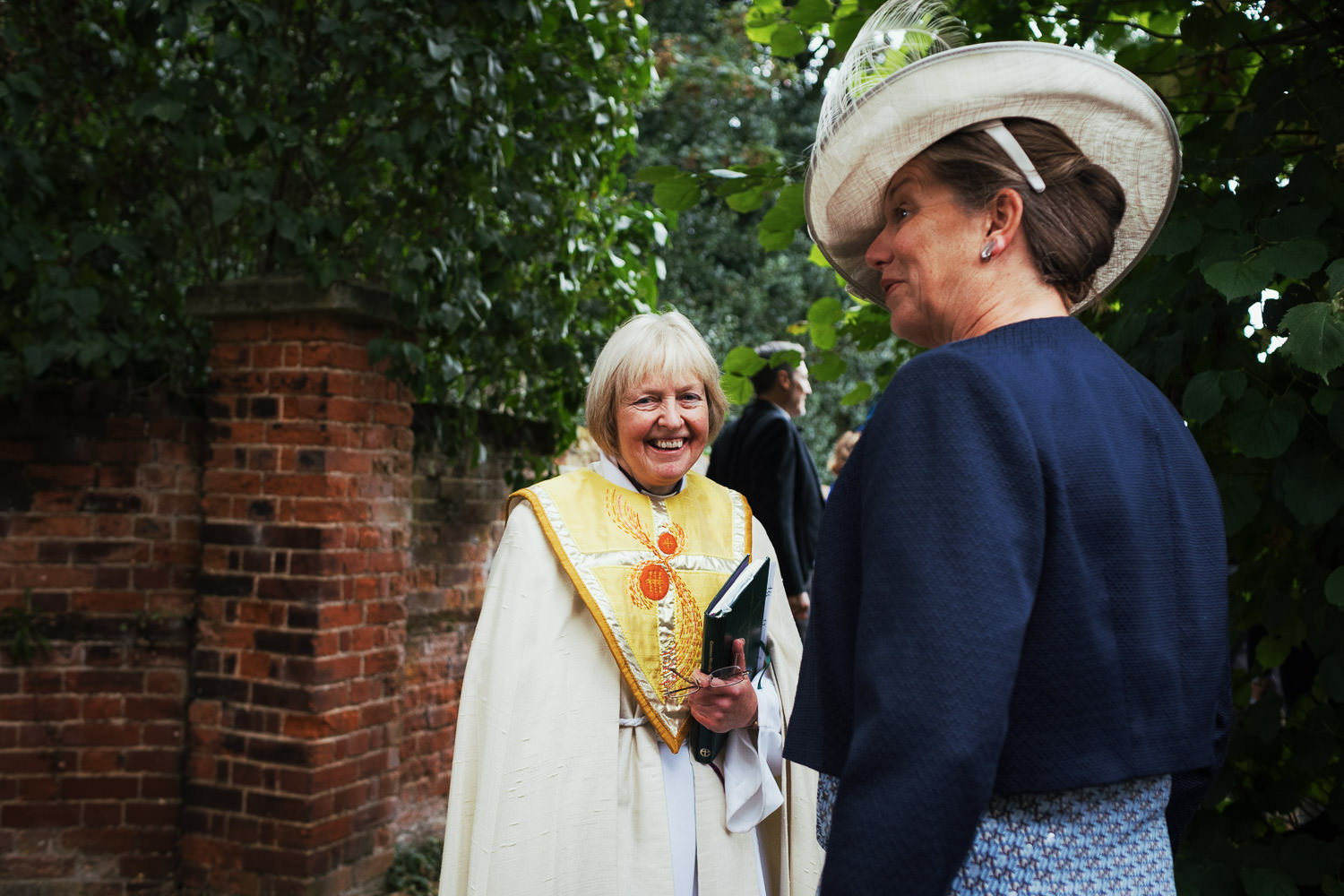 Revd Canon Jacqui Jones smiling at the camera in the grounds of the Parish Church of St John Baptist in Danbury after a wedding.