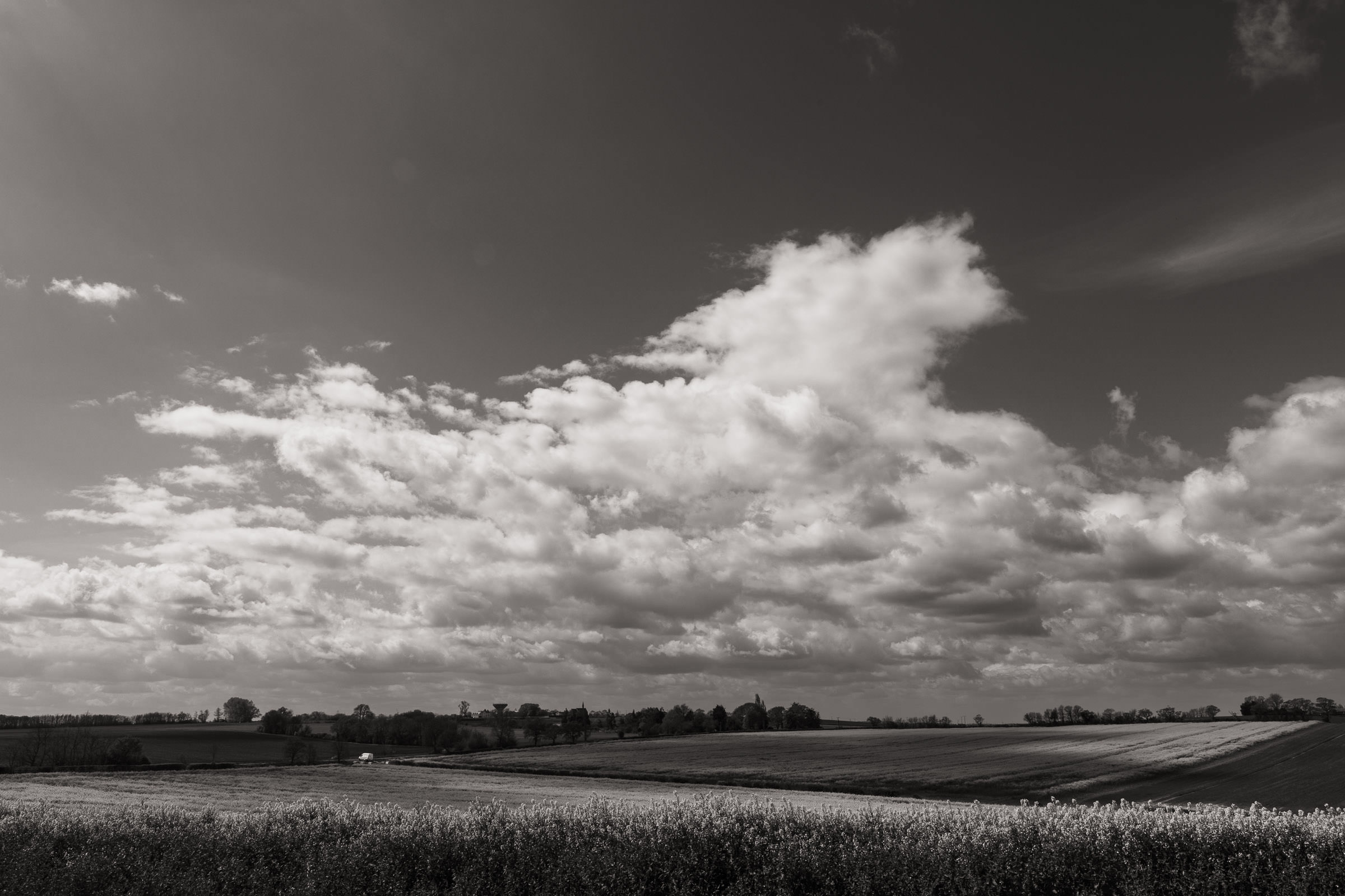 From Essex & Maldon wedding photographer. A black and white landscape photograph of a view over Bradwell Road and Maldon Road looking towards Southminster. From Highfields wedding venue in Bradwell-on-Sea.