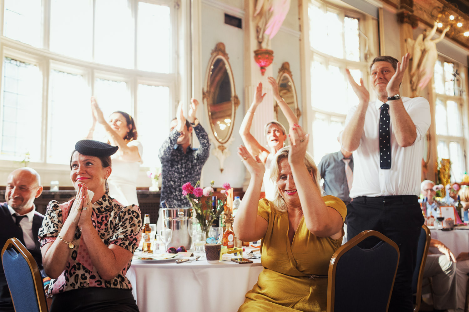 Wedding guests clapping the speeches at a table.