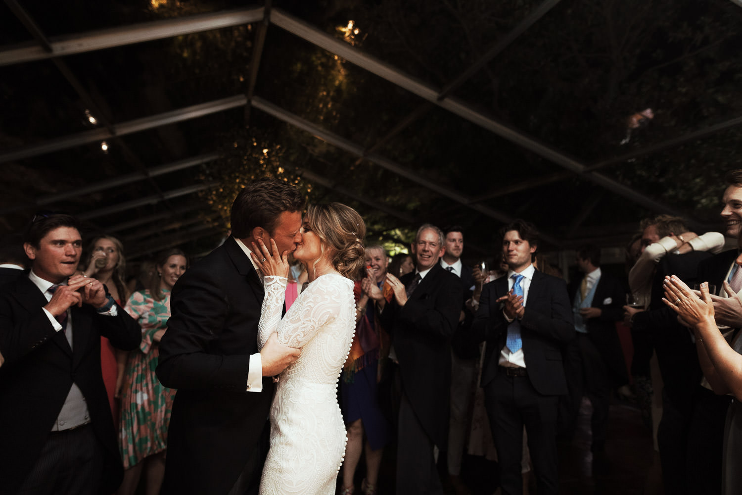 Wedding photography near South Woodham in Essex of a kiss at the end of the first dance. 
A clear marquee in a garden wedding. 