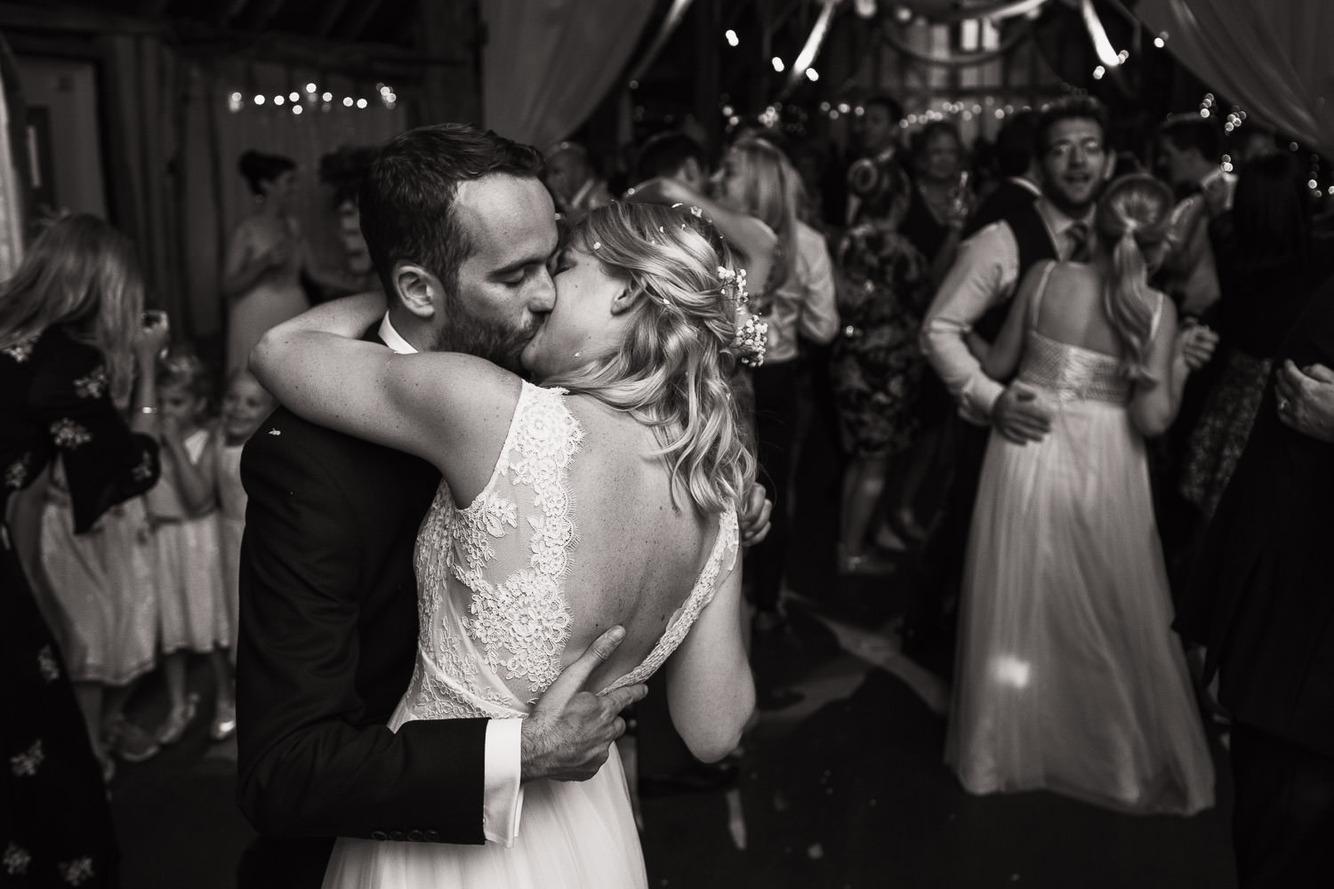 black and white photography of newly married dancing and kissing at Alpheton Hall Barns.