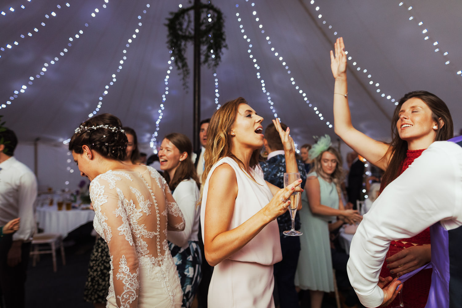 Women singing and dancing in a marquee.