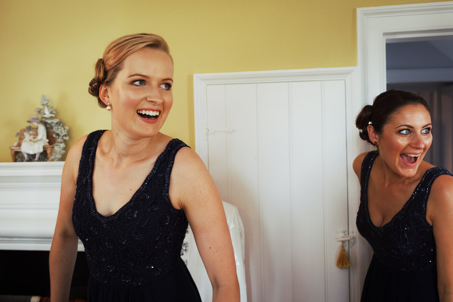 Bridesmaid entering a yellow bedroom and smiling.