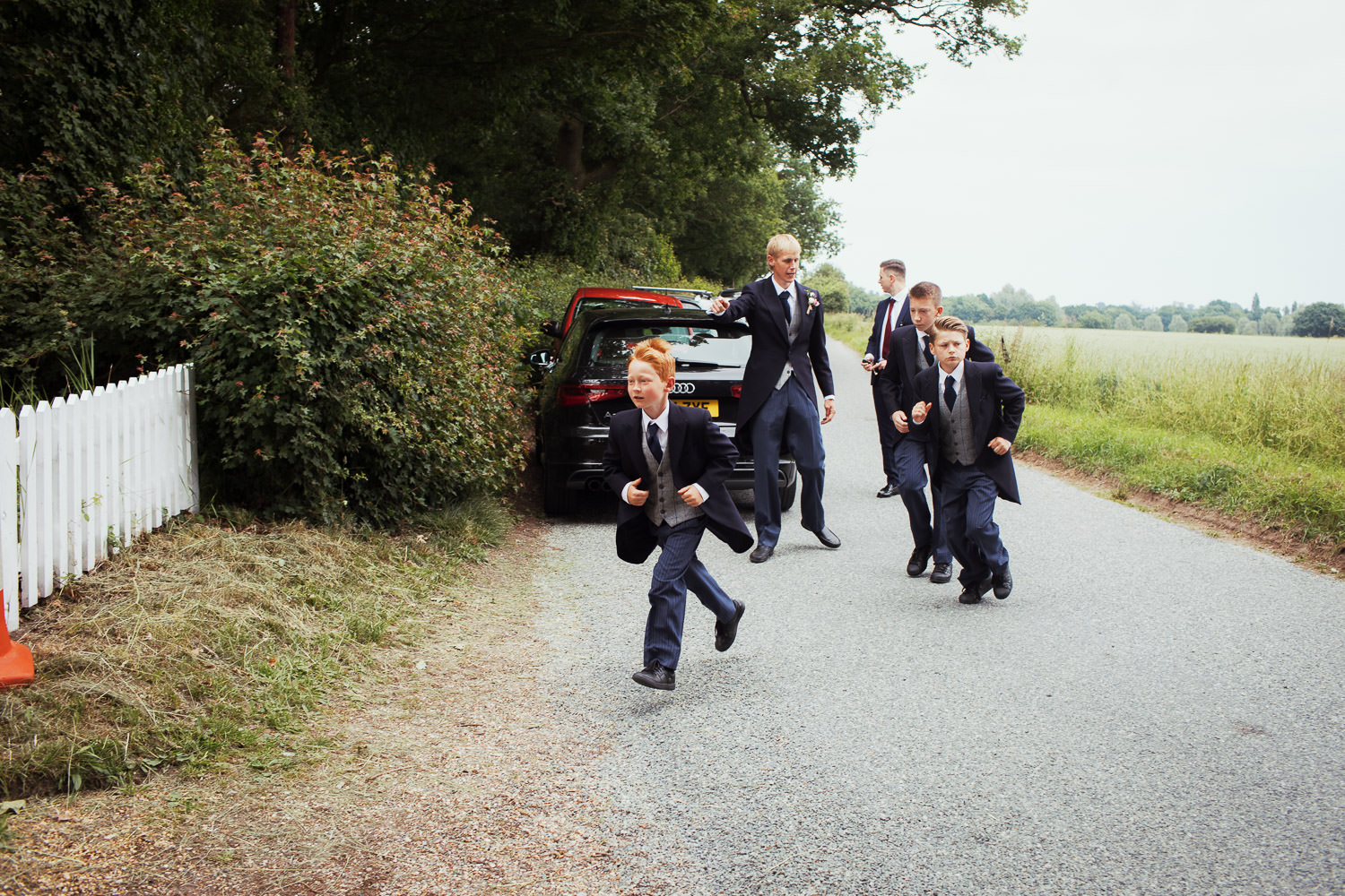 Page boys running across the road to St Peter's Church, Great Totham.