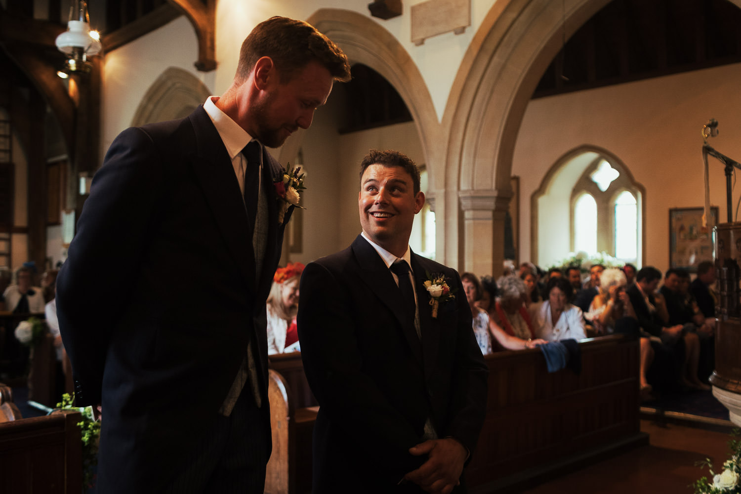 Groom waiting inside St Peter's Church in Great Totham. He's looking up at the best man.