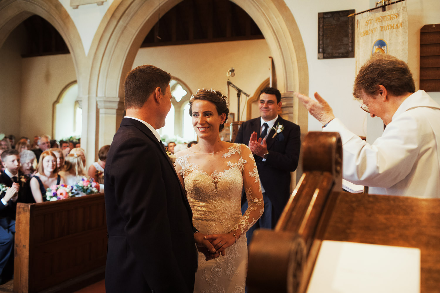 Bride and groom taking vows in the church in Great Totham near Maldon.