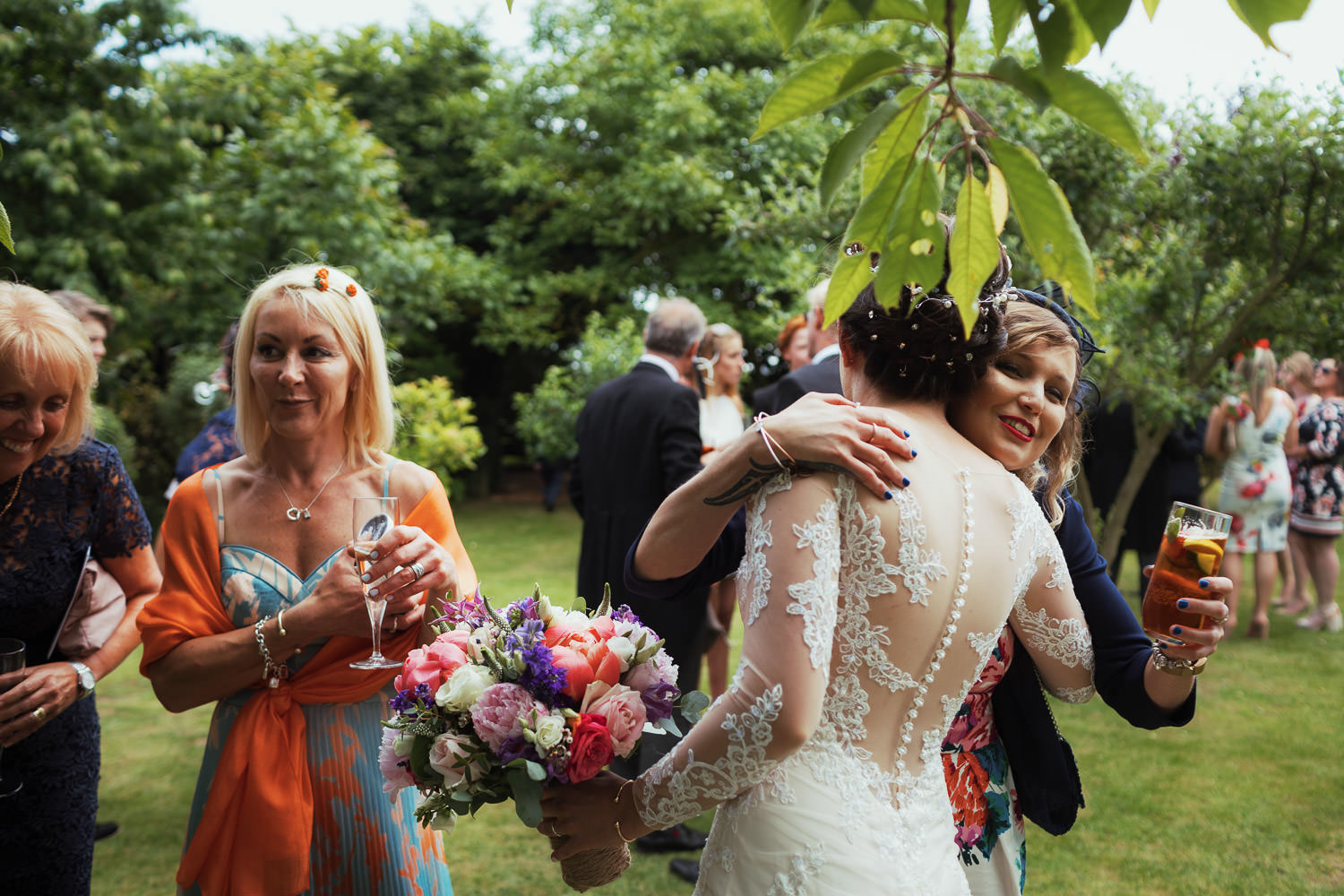 Bride hugging a woman drinking Pimms.