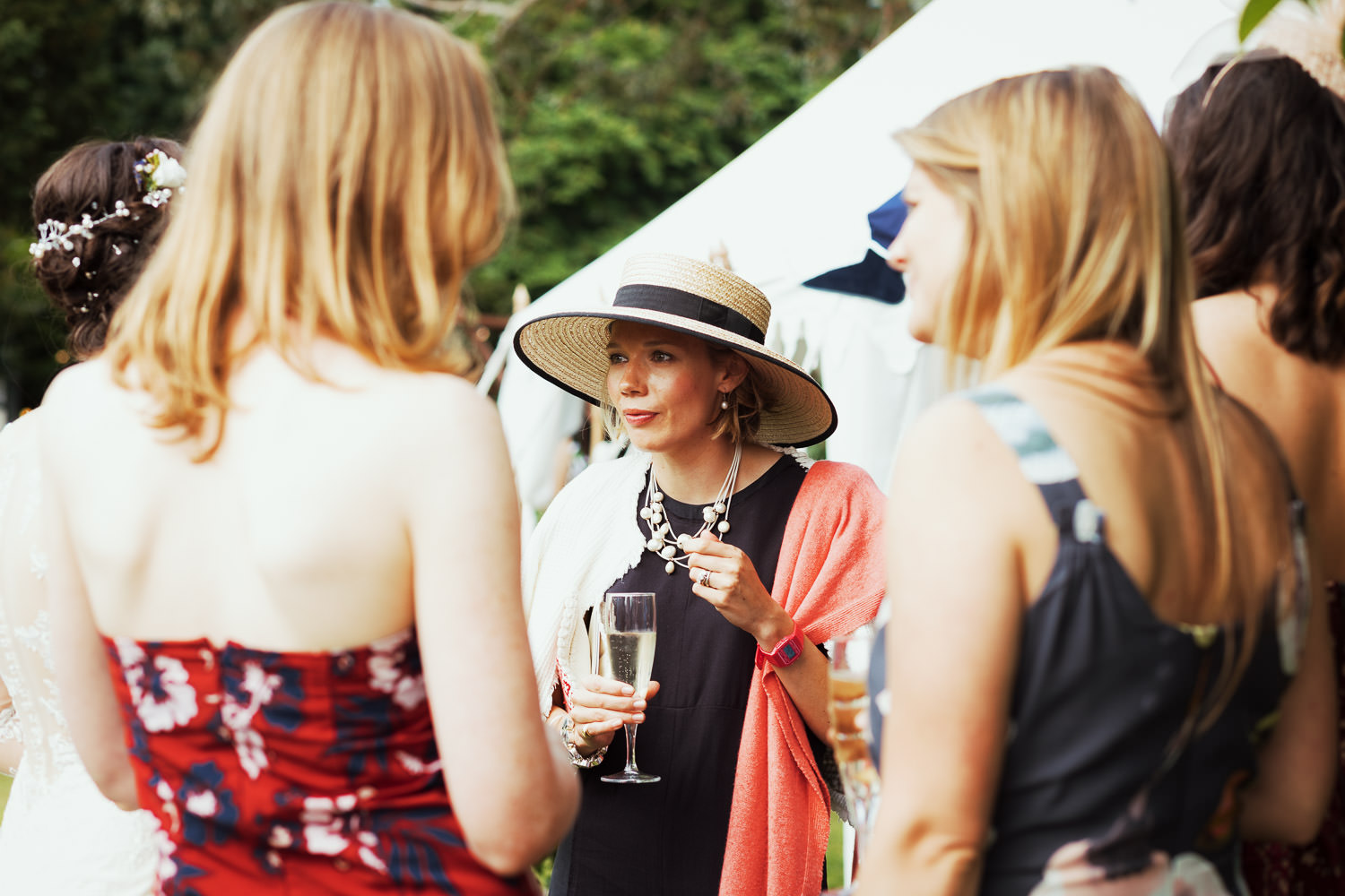 Woman in a hat holding a glass of champagne.