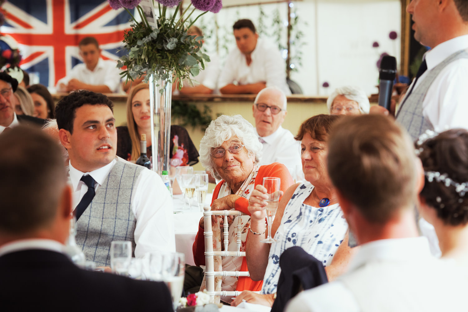Woman watching the groom give a speech.