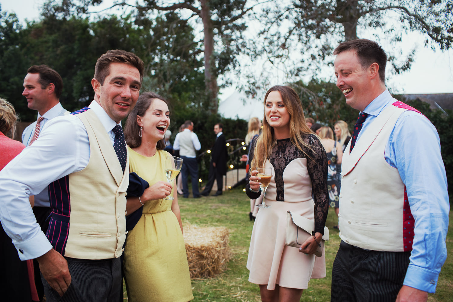 Four people laughing outside at a Maldon wedding.