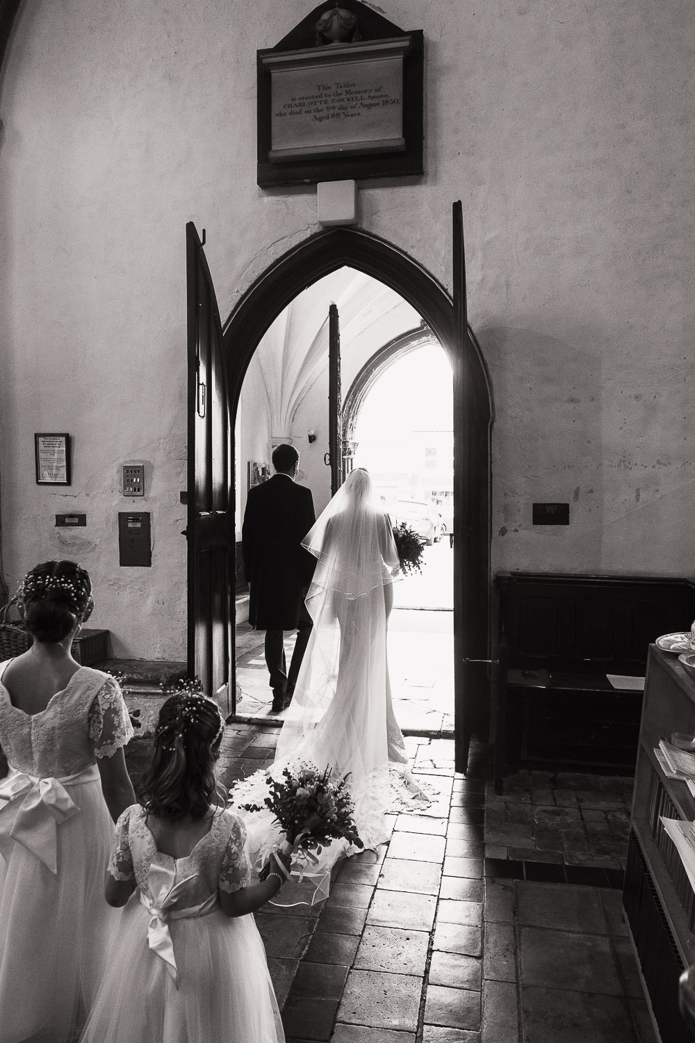Bride and groom walking through the door of St Mary's, Attleborough