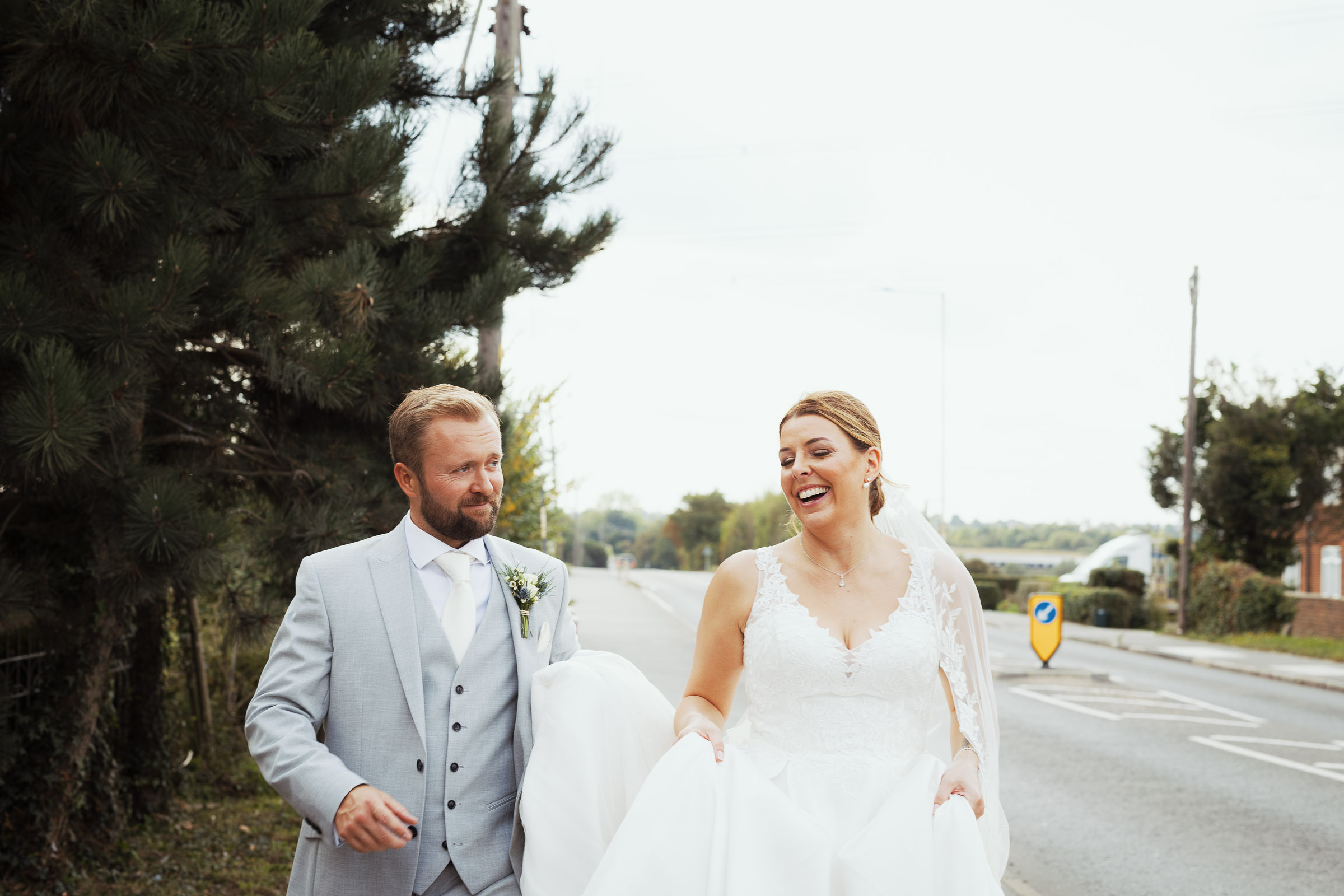 A bride and groom walking down the road outside The Lion House in Chelmsford on their wedding day.