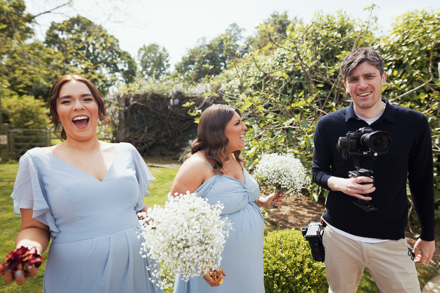 Philip Smith Visuals wedding film maker stood with bridesmaids. They are laughing at him! At Houchins wedding venue.