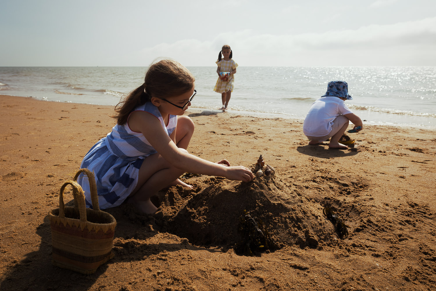 Children playing in the sand on a sunny day. A family photoshoot in Essex. Frinton beach.