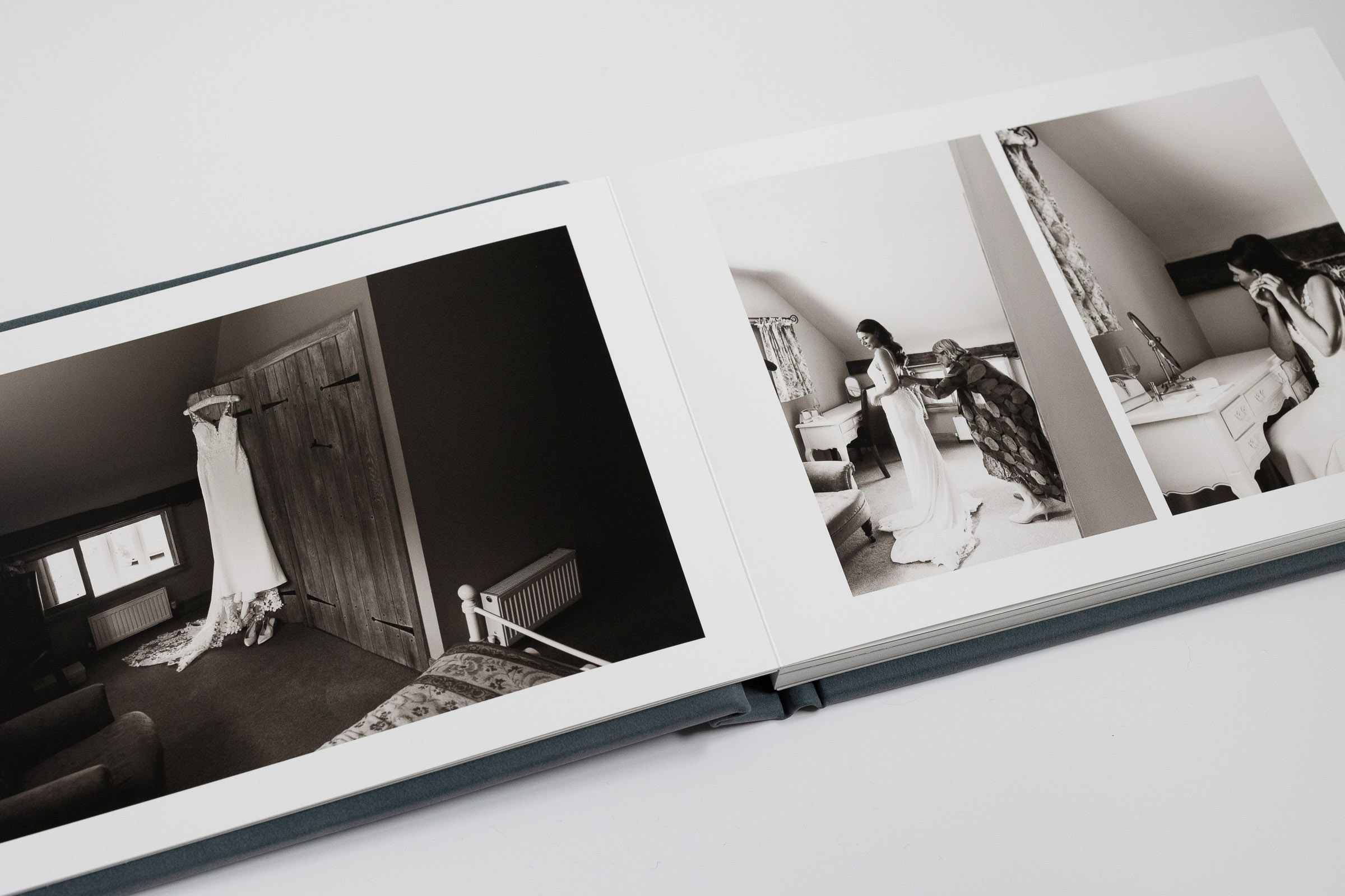 Folio wedding album: Fine art book in landscape with River-colored leather cover. Black and white bridal preparations photos at The Priory Dairy, Lavenham, by documentary wedding photographer Tracy Morter Photography in Essex.
