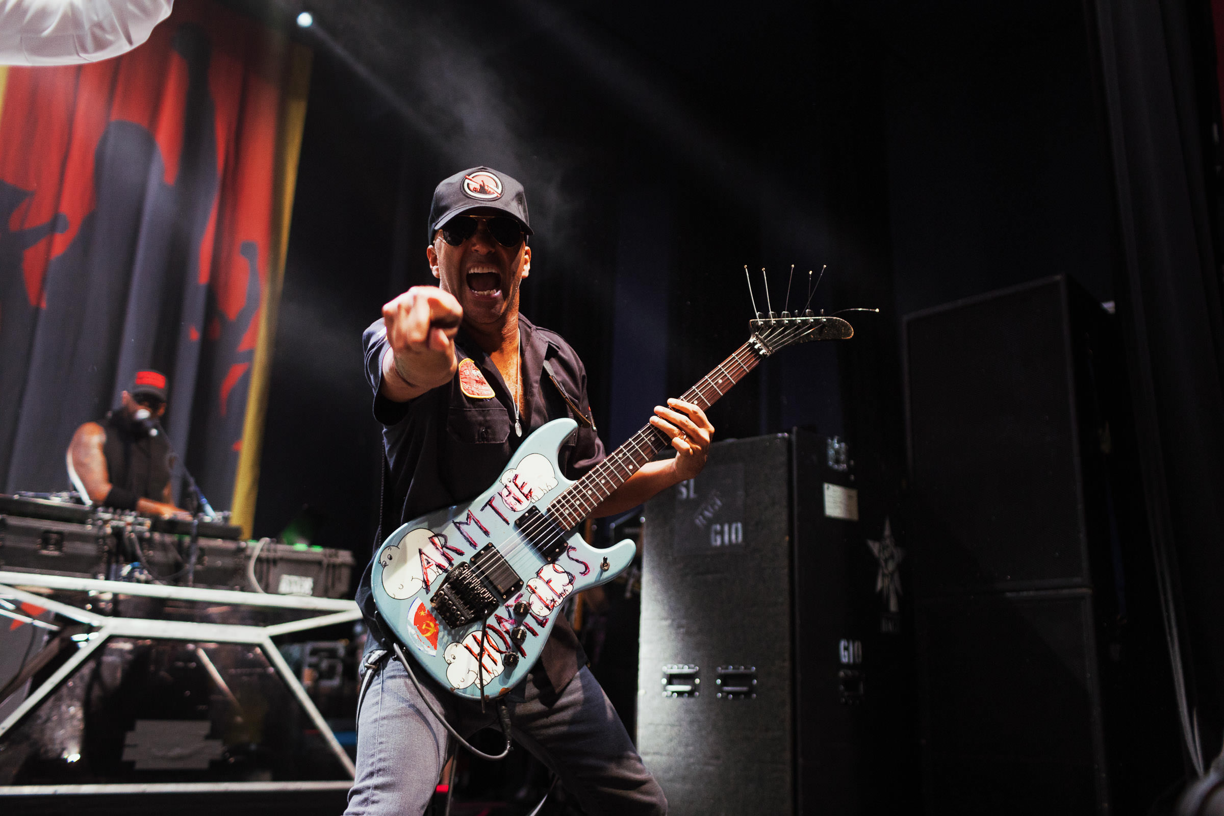 Tom Morello playing the Arm the Homeless guitar with Prophets of Rage, and pointing at the photographer Tracy Morter of the Christmas campaign.