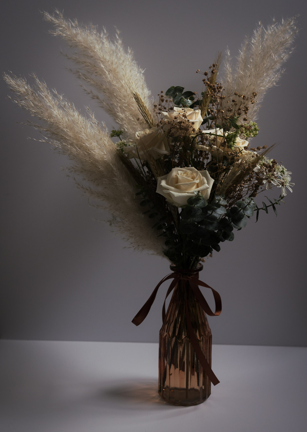 A small bohemian style bouquet in a brown vase by Delicate Daisy florist in South Woodham Ferrers. 